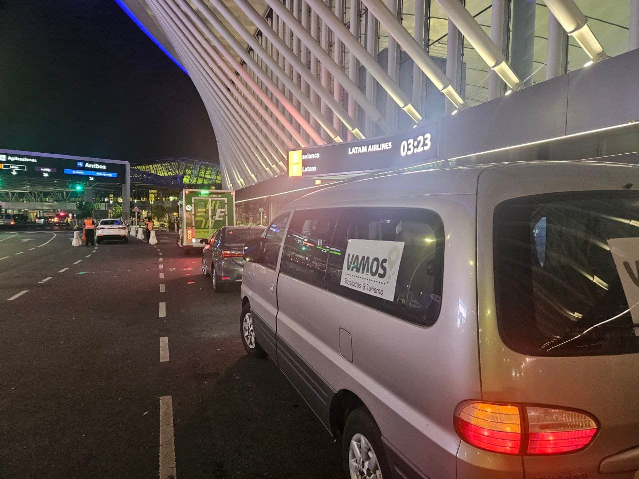 Van de Vamos Traslados & Turismo en la puerta de Arribos del aeropuerto de noche